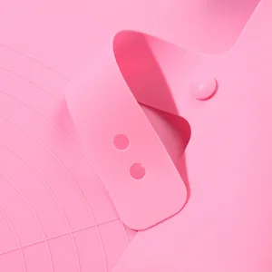 Close-up of pink silicone baking mat with storage buckle and embossed measurements