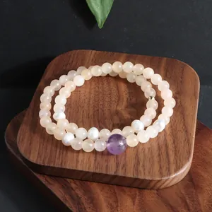 Luxe dubbele kralenarmband met natuurlijke jade, amethist en parels op houten basis