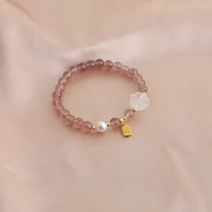 Exquisite strawberry quartz beaded bracelet featuring a white cat paw and blessing charm