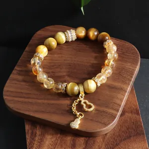 Detail of natural tiger eye stone bracelet with a sparkling crystal gourd charm