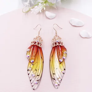 Detailansicht eleganter Ohrhänger mit Schmetterlingsflügel-Gradient und funkelnden Strasssteinen