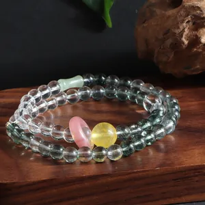 Macro detail of a new style double-strand crystal bracelet with green phantom and citrine beads.