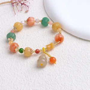 Nahaufnahme eines ethnischen Armbands mit Kürbisperlen aus Jade und Anhänger