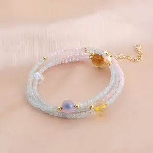 Détail d'un bracelet et collier à trois rangs en perles de cristal d'aigue-marine en couleurs.
