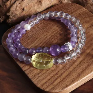 Détail d'un bracelet double rang améthyste et quartz clair avec perle et charme lion