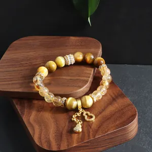 Detailed view of yellow tower crystal and tiger eye stone bracelet with gourd charm