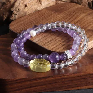 Vue détaillée du bracelet double rang en améthyste et cristal avec breloque lion sculpté.