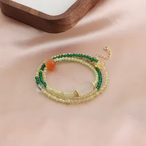 Détail d'un bracelet en pierres naturelles à couches avec perles vertes et pendentif jade