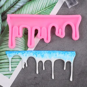 Detailed view of a pink silicone drip mold with a finished blue and white resin casting
