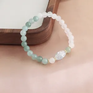 Detailansicht eines frischen Naturkristall-Armbands mit grünen und weißen Perlen.