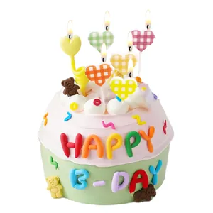 Colorful checkered heart candles on a mini decorative Happy Birthday cake topper