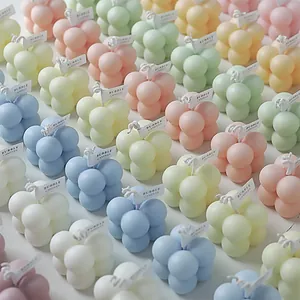 Filas decorativas de velas de burbujas en tonos pastel con pequeñas etiquetas blancas