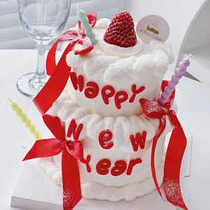 Festive Happy New Year cake decoration with red ribbons and soft rubber letters