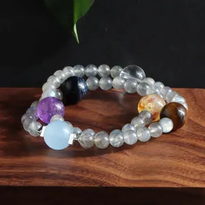 Macro view of double-layer natural stone bracelet with grey moonstone and amethyst beads.
