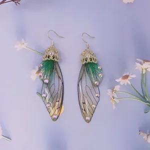 Detailansicht grüner Schmetterlingsflügel-Ohrringe mit Glitzer und Strass für Bräute