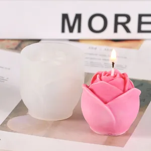 Primer plano de un molde de silicona con forma de rosa y una vela rosa terminada