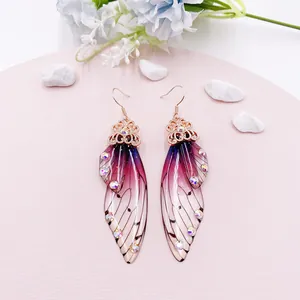 Nahaufnahme eleganter lila Farbverlauf Zikadenflügel Ohrringe mit Kristallakzenten und Goldhaken