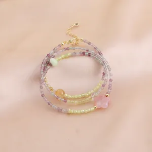 Détail d'un collier de perles en fluorite et calcédoine à plusieurs rangs avec fleur rose