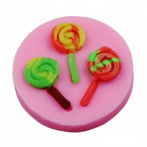 Detalle de un molde de silicona rosa con tres piruletas de fondant de colores vivos