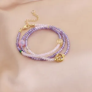 Détail d'un bracelet enveloppant à plusieurs rangs en perles de cristal violettes