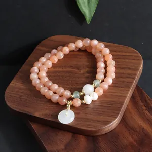 Nahaufnahme eines zweireihigen Sonnenstein-Armbands mit Jade-Donut und Perle