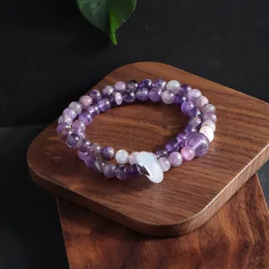 Detailed macro shot of a multi-layer natural amethyst bead bracelet with a white jade ring