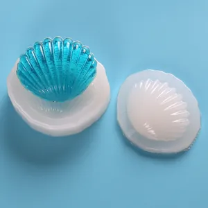 Dettaglio di uno stampo in silicone a conchiglia e pezzo finito in resina trasparente blu