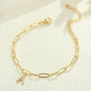Primer plano de pulsera de cadena clip dorada con un colgante de letra A de circonita