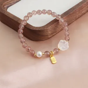 Exquisite natural strawberry quartz bracelet featuring a cat paw charm and a gold lucky tag