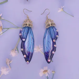 Detaillierte Nahaufnahme von blauen Schmetterlingsflügel-Ohrringen mit Strasssteinen