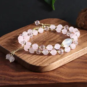 Elegant double-layer rose quartz beaded bracelet with gold accents and tassel detail.