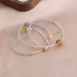 Vue détaillée de bracelets en perles de cristal aigue-marine et rose avec touches dorées.