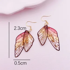 Detailed macro view of pink gradient cicada wing earrings with gold foil and dimensions