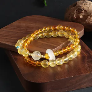 Macro detail of double-strand yellow citrine beaded bracelet with white jade ring accessory
