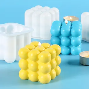 Detailed view of bubble cube silicone mold with finished candles in yellow and blue