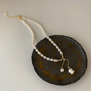 Elegante Süßwasserperlenkette mit weißem Muschelblumen-Anhänger Detail.