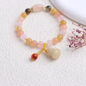 Detail des Natur-Jinsi-Jade-Perlenarmbands mit einem fein geschnitzten Kürbis-Anhänger.