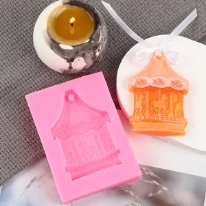 Pink carousel silicone mold shown with finished orange carousel wax ornament and candle