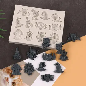 Detailed view showing a Halloween silicone mold alongside various bat, cat, and skull resin shapes.