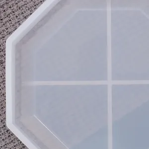 Primer plano de un molde de silicona octogonal translúcido para posavasos de resina epoxi DIY