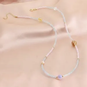 Collier et bracelet en cristal d'aigue-marine fait main sur fond de satin couleur pêche
