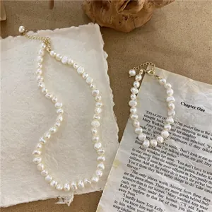 Macro view of vintage natural baroque pearl necklace and bracelet set with golden clasp