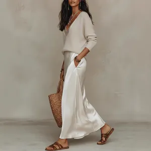 Ensemble 2 pièces élégant pour femme avec haut en maille beige et jupe longue en satin.
