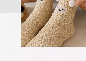 Nahaufnahme gemütlicher Korallenfleece-Socken mit besticktem Alpakagesicht und Plüschohren