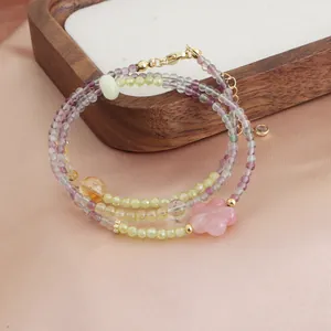 Détail du collier à triple rang de perles en fluorite colorée et calcédoine, fleur rose.