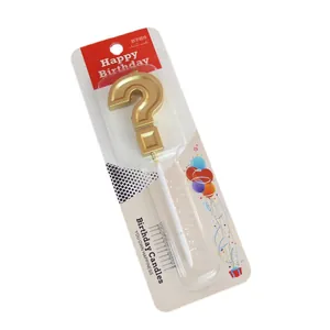 Golden question mark shaped birthday candle cake topper in blister card packaging