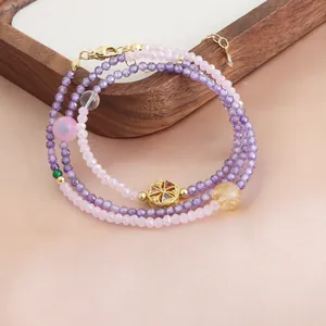 Gros plan d'un collier de perles de cristal violet et rose à trois couches