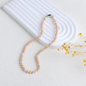 Élégant collier de perles de nacre multicolores avec fermoir métallique sur plateau de présentation