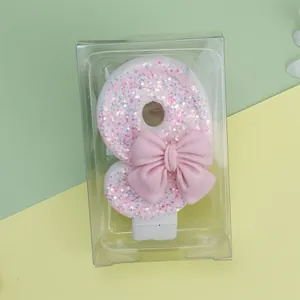 Detalle de vela de cumpleaños con purpurina número 8 y lazo rosa para decoración