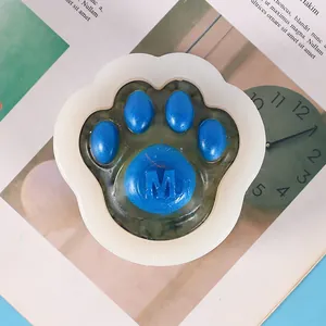 Detailed view of cat paw silicone mold with finished blue resin casting featuring letter M